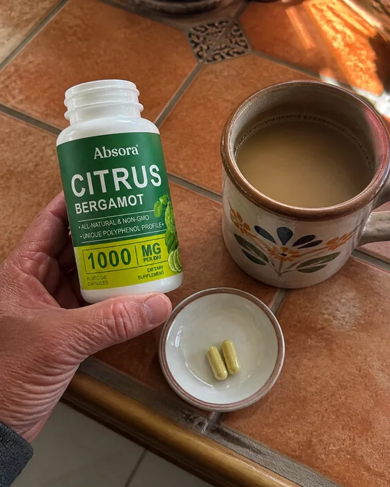 Citrus Bergamot bottle, capsule and coffee on a tiled table