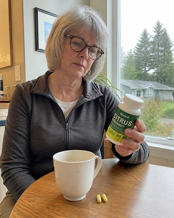 Retired woman holding Citrus Bergamot beside her coffee