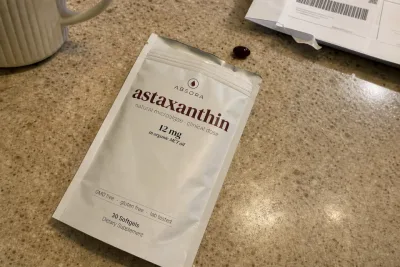 Opened Absora Astaxanthin pouch and one softgel on a customer's kitchen counter