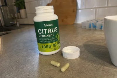 Opened Absora Citrus Bergamot bottle, cap and two capsules on a customer's kitchen counter
